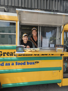 Two people in a yellow food truck